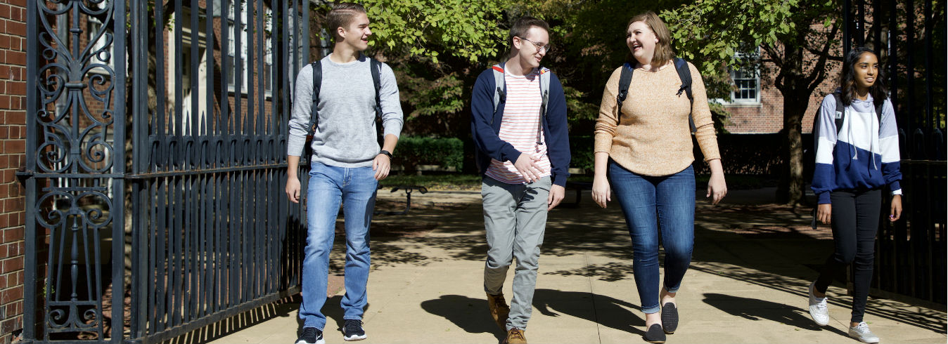 Four students walk out into the sunshine behind Wohlers Hall